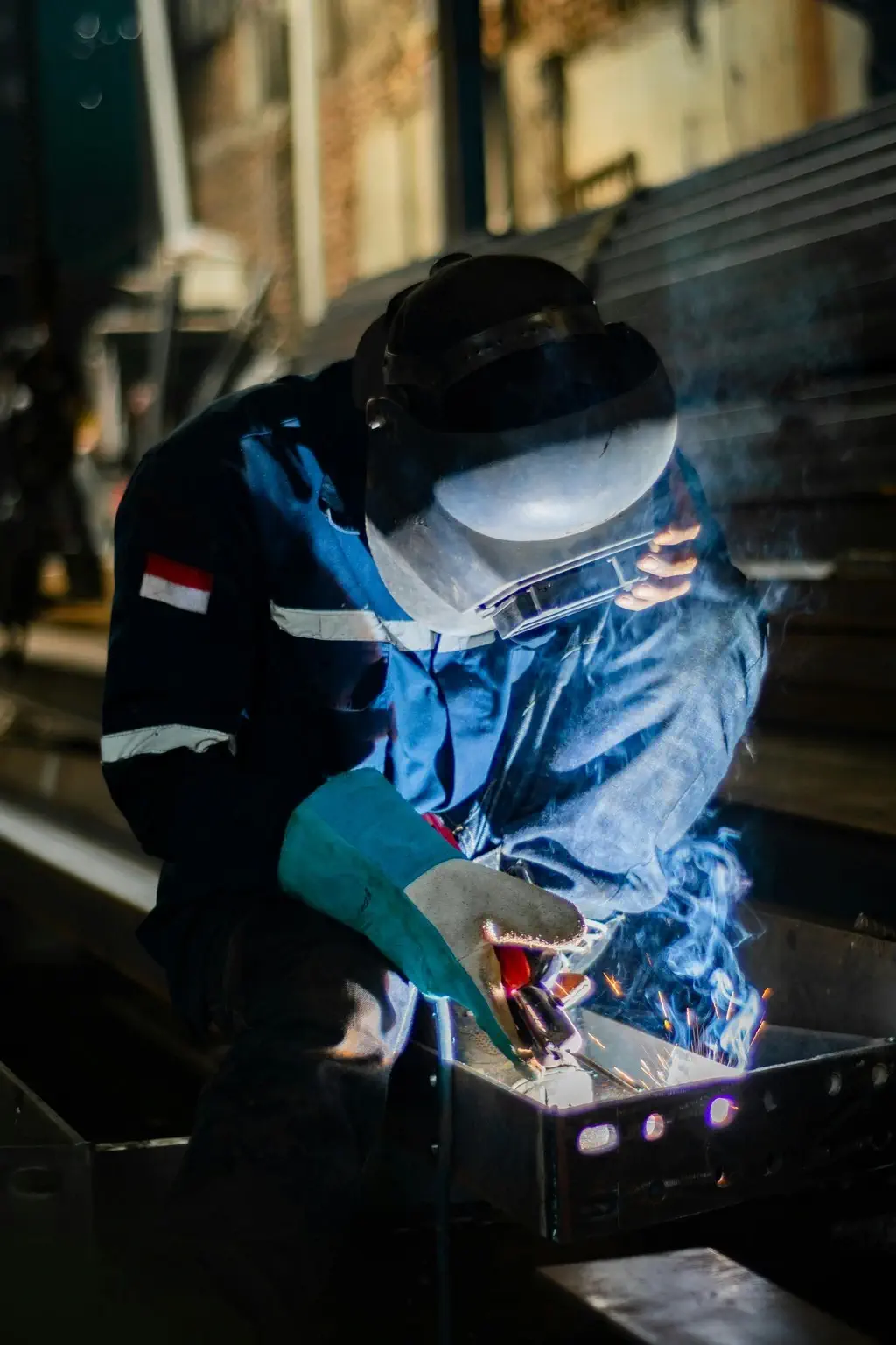 Welder in protective gear joining a steel bracket at Tuff Industries